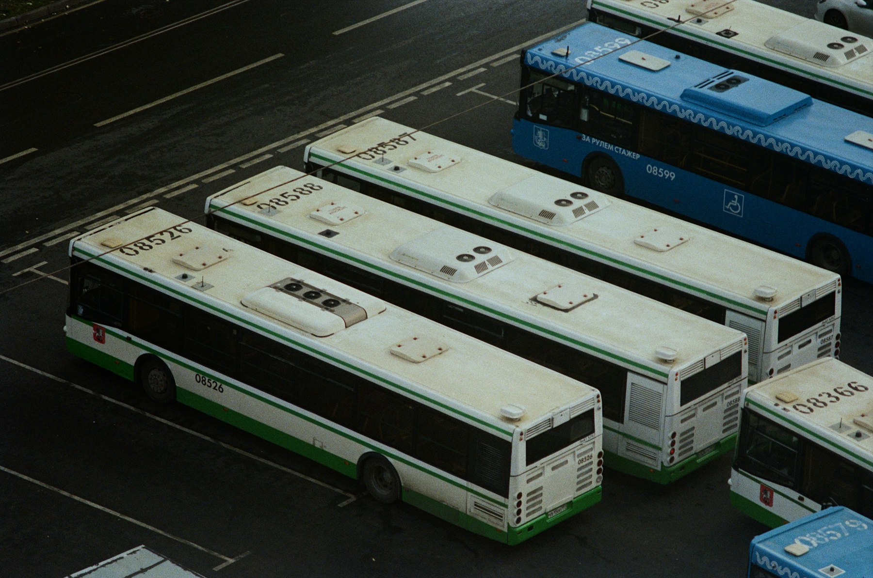 Frota de ônibus estacionada em pátio operacional, vista de cima